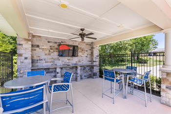 A patio with a table and chairs and a fan.